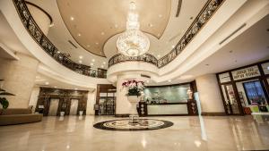 eine große Lobby mit einem großen Kronleuchter und einem Gebäude in der Unterkunft Super Hotel Candle in Hanoi