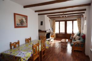 Un comedor y una sala de estar con mesa y sillas. en Casa Rural Os Arregueses, en Alquézar