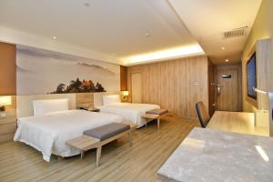 a hotel room with two beds and a table at Atour Hotel (Xi'an Gaoxin Dazhai Road) in Xi'an