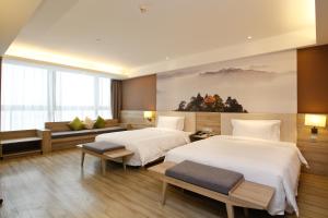 a hotel room with two beds and a large window at Atour Hotel (Xi'an Gaoxin Dazhai Road) in Xi'an