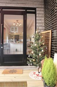 a christmas tree on a wooden table in front of a door at ANC HOUSE in Gangneung