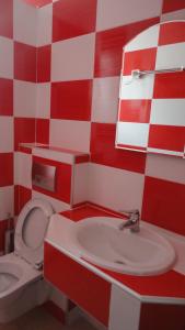 パラリア・カテリニスにあるImperia Presidentの赤と白のチェッカー付きバスルーム(トイレ、シンク付)