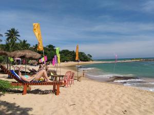 un grupo de personas sentadas en la playa en Golden Lodge Tangalle, en Tangalle