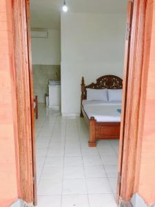 a bedroom with a bed and a white tiled floor at Lilacita Beach Lovina in Lovina