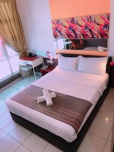 1 dormitorio con 1 cama grande y una pintura en la pared en Langit Langi Hotel @ KLIA/KLIA2, en Kampung Dengkil