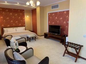 ウラジオストクにあるトム ホテルのベッド1台、薄型テレビが備わるホテルルームです。