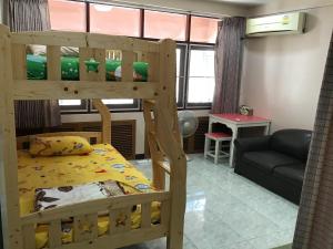 um quarto com 2 beliches e um sofá em D-Toys Homestay em Khon Kaen