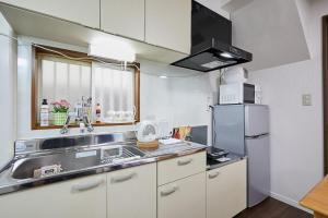 eine kleine Küche mit Spüle und Kühlschrank in der Unterkunft Ka's house in Tokio