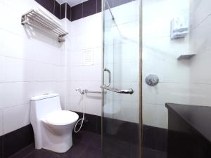 a bathroom with a toilet and a glass shower at Nova Kuching Hotel in Kuching