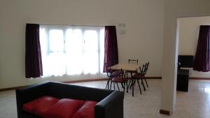 a living room with a couch and a table with chairs at Diez ApartHotel in Puerto Madryn