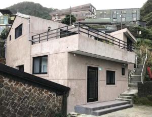 a house with a balcony on top of it at Lucky House B&B in Jiufen
