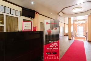 スービックにあるRedDoorz Plus @ Seaborne Hotel Subic Zambalesの赤いカーペット敷きの部屋とベッド付きの部屋