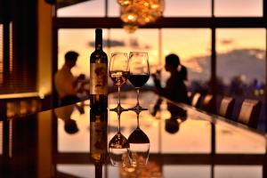 zwei Gläser Wein auf einem Tisch neben einem Fenster in der Unterkunft The Naha Terrace in Naha