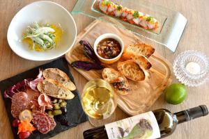 una mesa con un plato de comida y una botella de vino en The Naha Terrace, en Naha