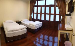 une chambre avec deux lits, un bureau et une fenêtre dans l'établissement Papermoon Guesthouse, à Bangkok