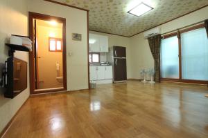 sala de estar con suelo de madera y cocina en Chamjoeun Pension en Jecheon