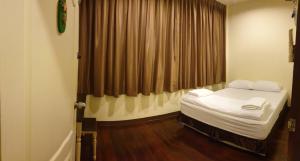 une petite pièce avec un lit et une fenêtre dans l'établissement Papermoon Guesthouse, à Bangkok