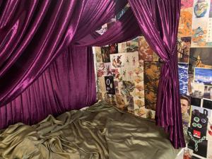 a bedroom with purple curtains and a bed at Wontonmeen in Hong Kong