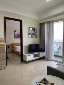 een woonkamer met een televisie en een spiegel bij Menteng Park 19th in Jakarta