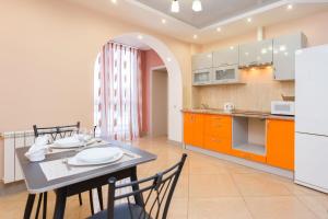 a kitchen and dining room with a table and chairs at Apartments Roomer 3 in Minsk