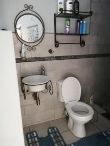 ein Badezimmer mit einem WC, einem Waschbecken und einem Spiegel in der Unterkunft Khaya la Manzi in Port Edward