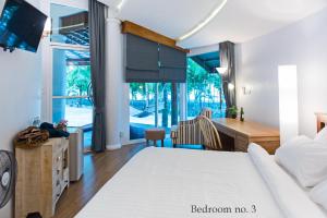 Koh Mak Cococape Resort في كو ماك: غرفة نوم بسرير ومكتب وطاولة