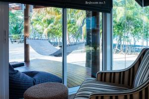 two chairs and a hammock in a room with a window at Koh Mak Cococape Resort in Ko Mak