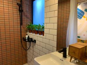 a bathroom with a sink and a shower with plants at Wontonmeen in Hong Kong