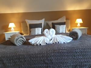 een bed met twee handdoeken en zwanen erop bij Eifel Dream Eulennest in Fleringen