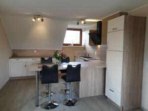 a kitchen with a table and black chairs at Eifel Dream Eulennest in Fleringen