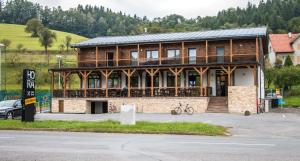 un gran edificio de madera con una bicicleta estacionada frente a él en Penzion HORA, en Ratiboř