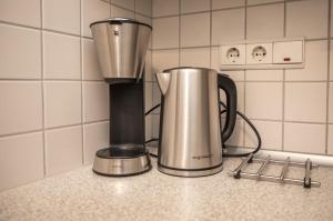 a coffee maker and a blender on a counter at Haus Dünenbake, Ferienwohnung Strandpeter Meerblick (Wohnung 47) in Sankt Peter-Ording