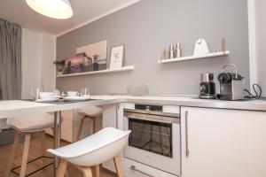 a kitchen with a white counter and a table and chairs at Haus Dünenbake, Ferienwohnung Strandpeter Meerblick (Wohnung 47) in Sankt Peter-Ording