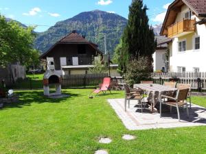 a patio with a table and chairs in a yard at Hutmannhof-Ferienwohnungen in Dellach