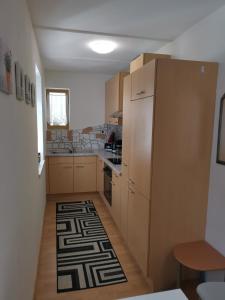 a kitchen with wooden cabinets and a rug on the floor at Studio Stefan in Umhausen +14 photos
