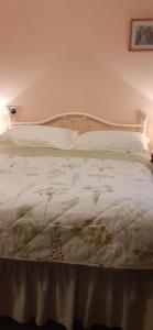 a bedroom with a bed with white sheets and pillows at Church Farm in Stratford-upon-Avon