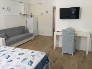 a living room with a couch and a desk and a television at Residenza Solferino in Corniglia