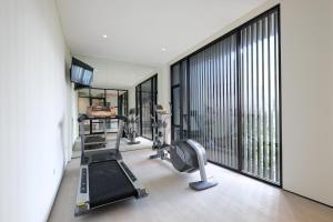 a gym with tread machines and a large window at La Boheme, Rooms and Coffee in Jakarta