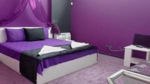 a purple bedroom with a bed with a purple wall at Бора Бора in Sapareva Banya
