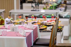 a table with pink and white clothed tables with food at Sealife Family Resort Hotel in Antalya