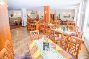 a restaurant with wooden tables and chairs with yellow napkins at Waldhotel Friedrichroda in Friedrichroda