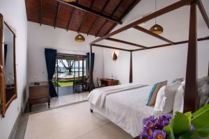 a bedroom with a bed and a window at Saltasia Boutique Beach Villa in Mirissa