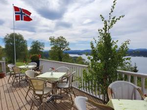 a deck with tables and chairs and a flag at Westland Hotel in Lindås
