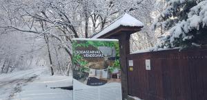 a sign on the side of a building in the snow at Csodaszarvas Vendégház in Sály