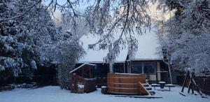 Csodaszarvas Vendégház في Sály: منزل مغطى بالثلج مع منزل