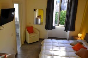 1 dormitorio con 1 cama, 1 silla y TV en S'arenada en Cagliari