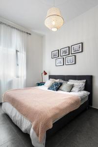 a bedroom with a large bed and a chandelier at Urban Luxe Apartment - Central TLV by Sea N' Rent in Tel Aviv