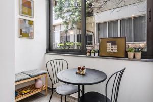 mesa y sillas en una habitación con ventana en Urban Luxe Apartment - Central TLV by Sea N' Rent en Tel Aviv