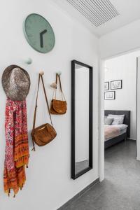a clock and a mirror on a wall in a bedroom at Urban Luxe Apartment - Central TLV by Sea N' Rent in Tel Aviv