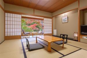 a room with a table and chairs and a window at Ranzan in Kyoto